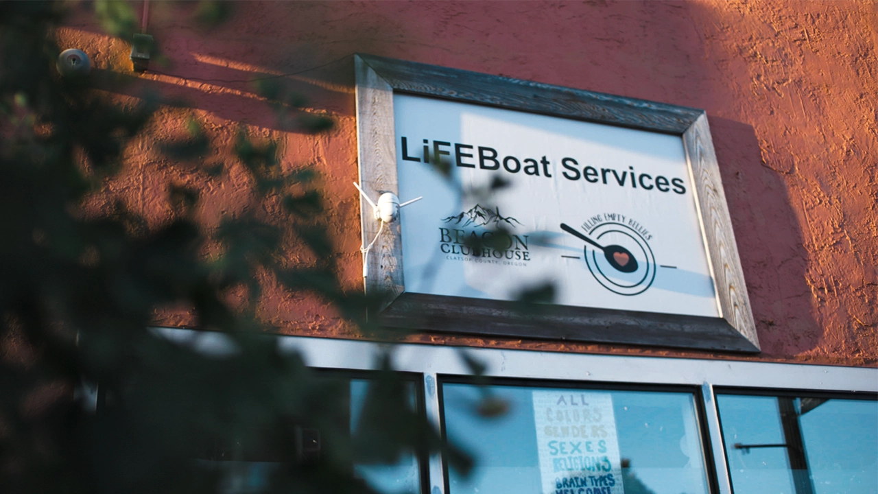 Close-up image LiFEBoat Services signage on a building with a tree also in view